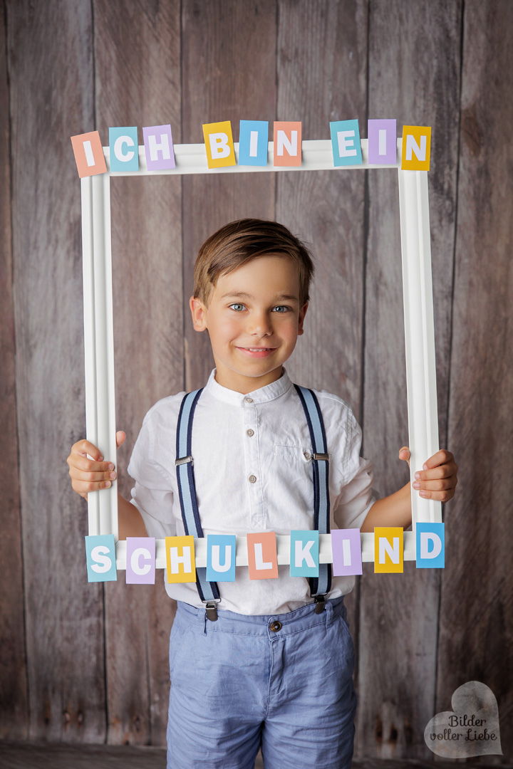 Einschulungsfoto mit stolzem Kind und liebevoller Studiodekoration